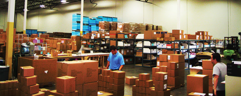 Workers in warehouse preparing boxes.