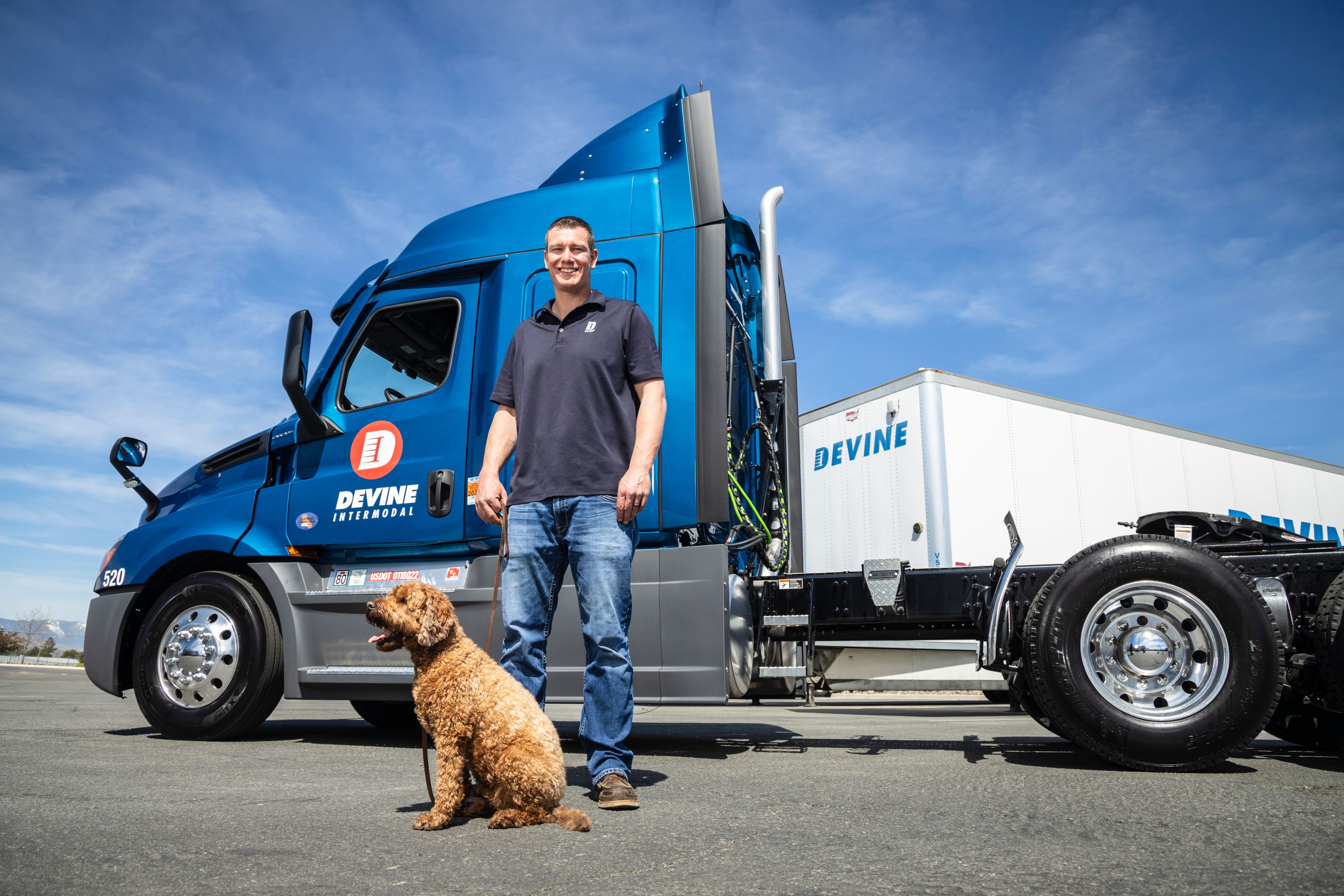 Devine Intermodal employee and dog standing in front of Devine truck
