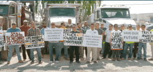 A bunch of truck drivers on strike holding signs