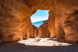 a view from inside the cave looking up a blue skies