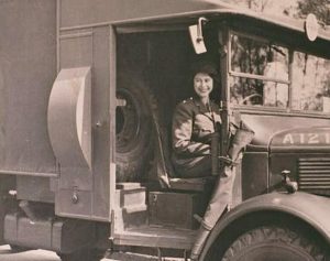 Black and white photo of Queen Elizabeth II driving a big truck before she was Queen.