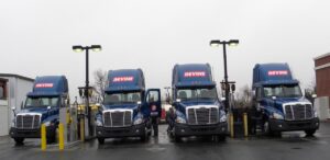 Four devine trucks lined up at the fuel island.